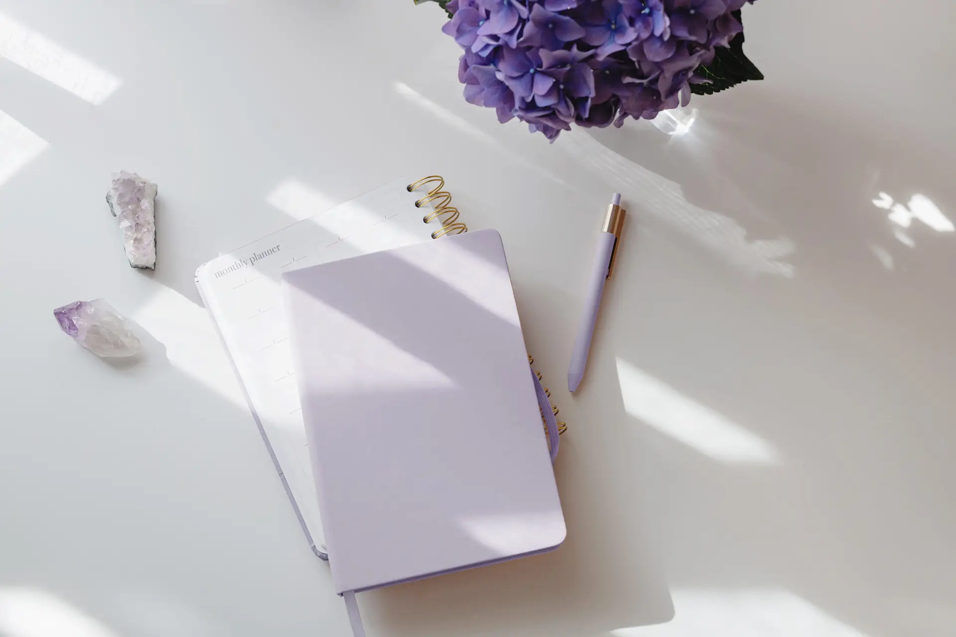 planner on desk with crystals and hydrangea flower